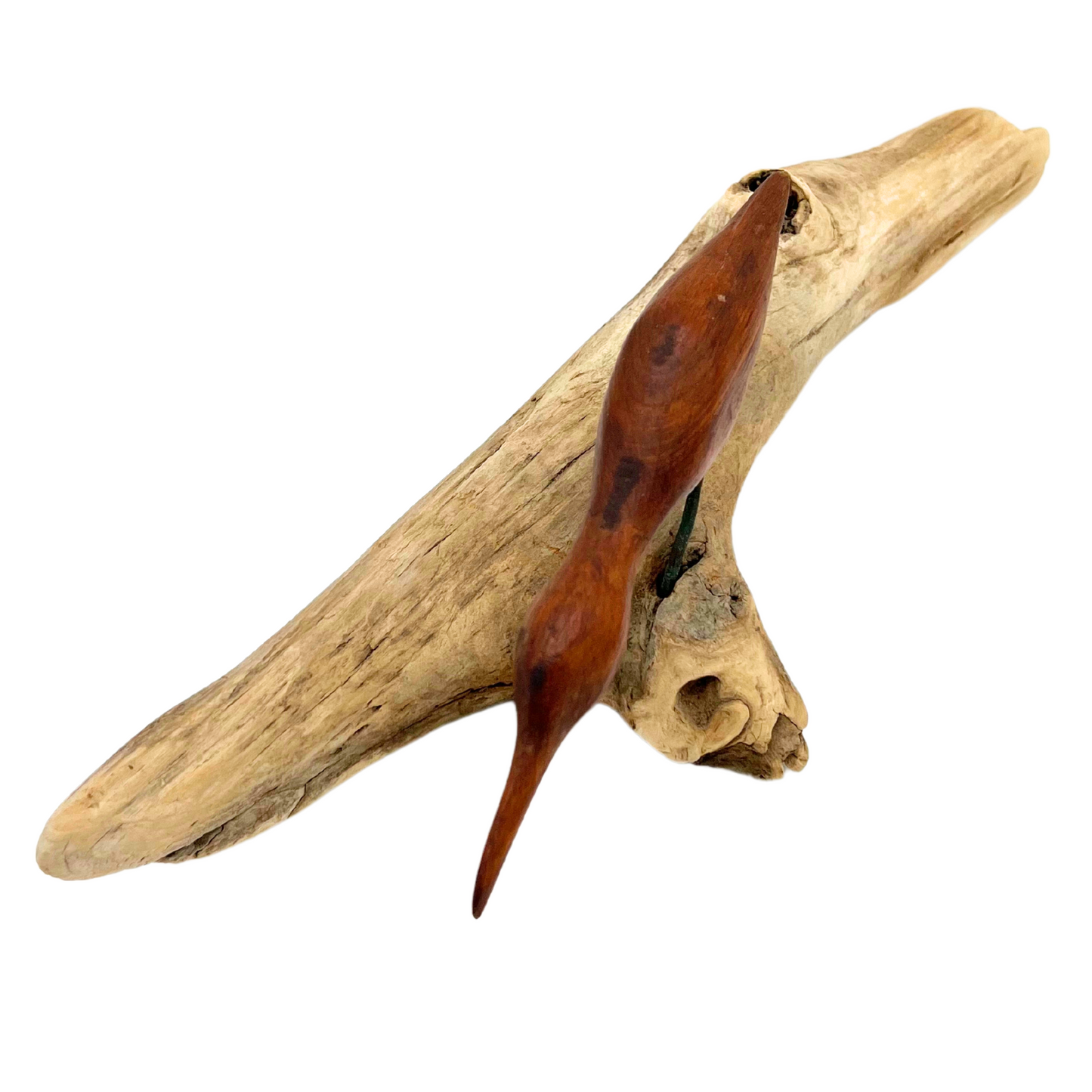 carved wooden shore bird on driftwood